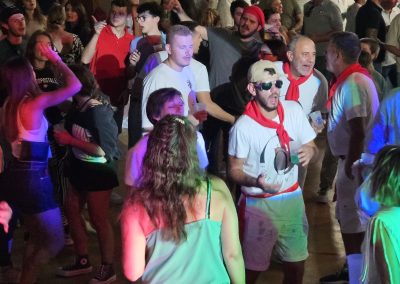 Ambiance festive sur la piste de danse lors d’une soirée années 80 animée par un DJ, public nombreux et éclairages colorés.