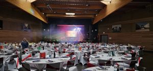 Installation DJ avec écran vidéo et éclairage scénique dans une grande salle des fêtes avant le début de la soirée.